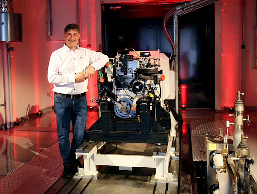 AGCO Powerin tuotekehitysjohtaja Kari Aaltonen vetypolttomoottorin edustalla uudessa puhtaan energian laboratoriossa. Kuva AGCO Power.